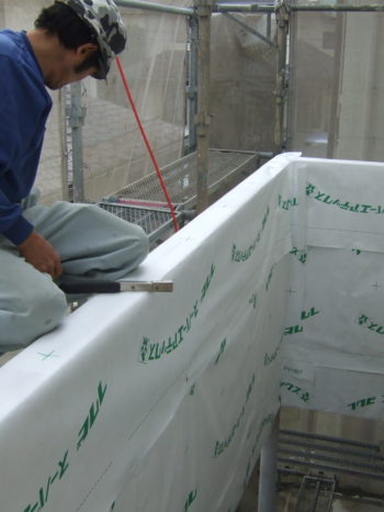 I様邸のベランダ腰壁に透湿紙を貼っている様子