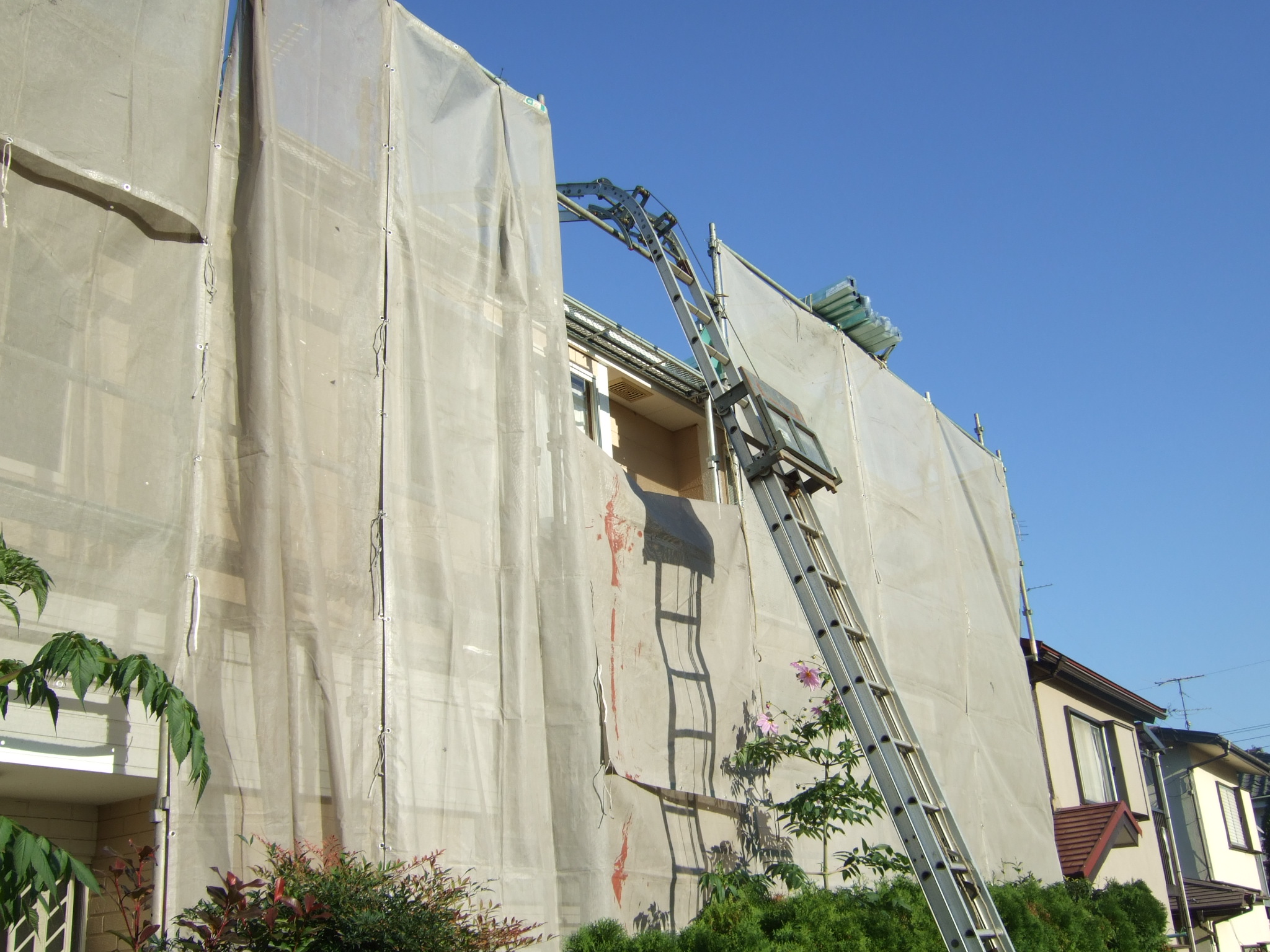 K様邸の屋根材を梯子で上げている様子