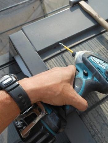 守谷市M様邸の屋根棟板金をビスで固定している様子