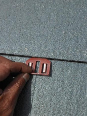 龍ケ崎市N様邸の屋根コロニアルにタスペーサーを挿入している様子